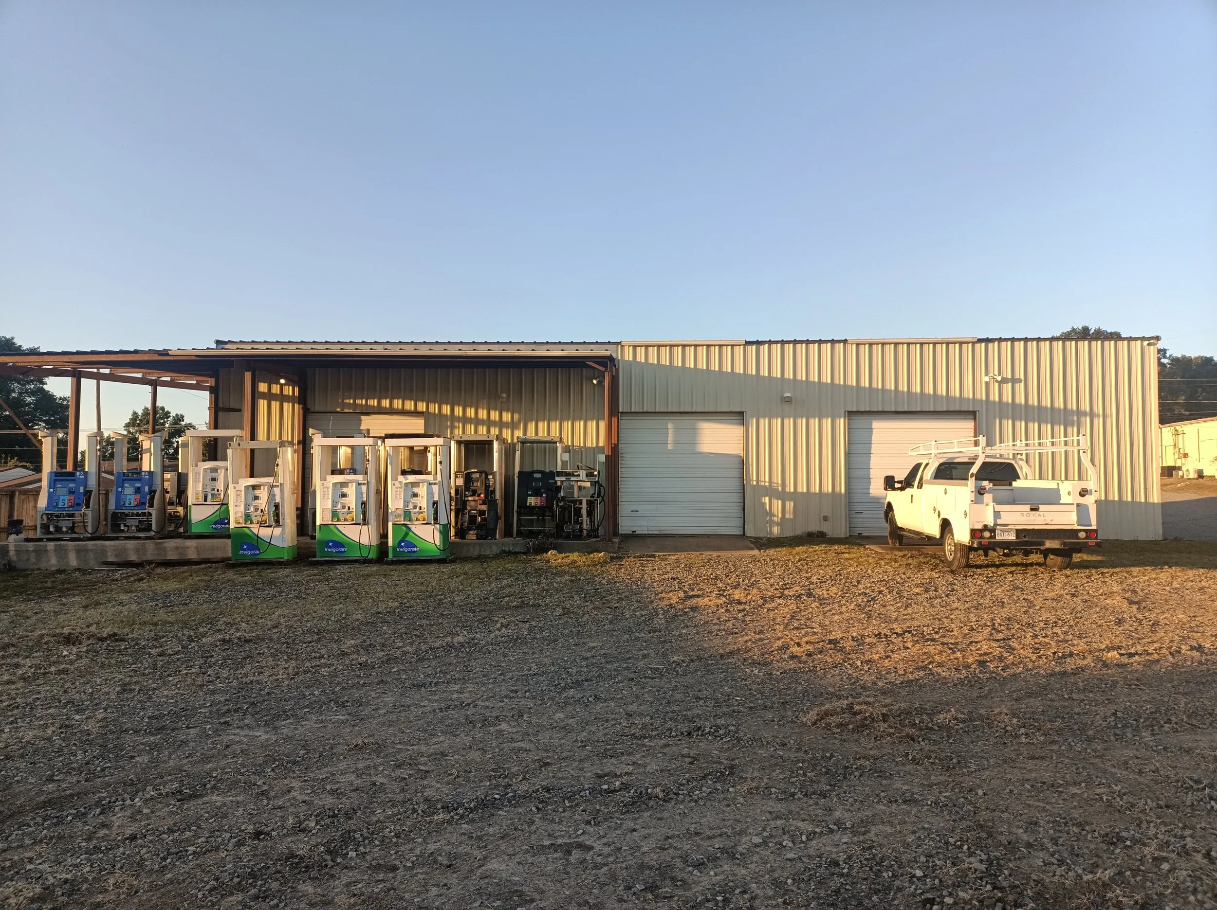 The Natural State Pump shop and service yard in Searcy, with fuel dispensers lined up outside and a service truck parked alongside.
